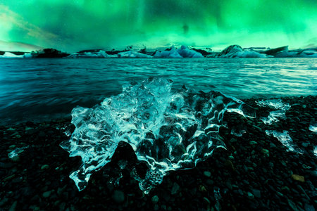Stunning view of Aurora borealis, Northern lights glowing over abstract iceberg in Jokulsarlon...