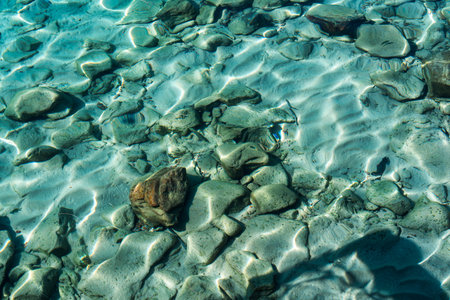Crystal clear shallow water with ripples and stones in tropical seaの写真素材
