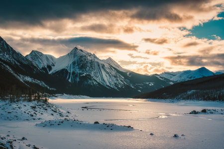 Beautiful scenery of sunrise over Medicine Lake with rocky mountains and frozen lake in Jasper...