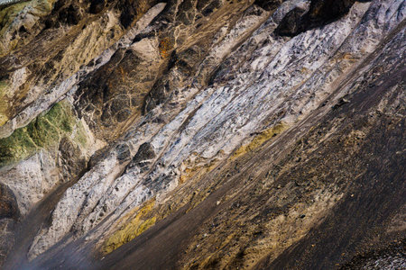 Geological layers of colorful volcanic rock formation with mineral sulfur, lava and snow on rugged...
