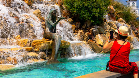 Marmaris, Turkey - May 01, 2022 - Mermaid statue in the waterfall at Fountain Square in Marmaris with female touristのeditorial素材