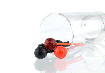 Red and black lollipops poured from a glass