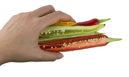 Hand grabbing sliced chili peppers isolated on white backgroundの写真素材