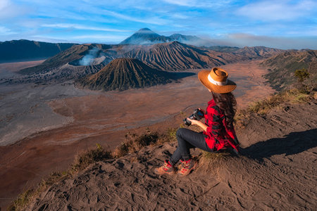 Woman traveler taking photo of Bromo volcano in Bromo Tengger Semeru National Park, East Java, Indonesiaの写真素材