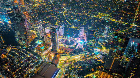 Night aerial view of skyscrapers and multi lane highway in large urban city center Cityscape of high rise buildings in Jakarta, Indonesia at nightの写真素材