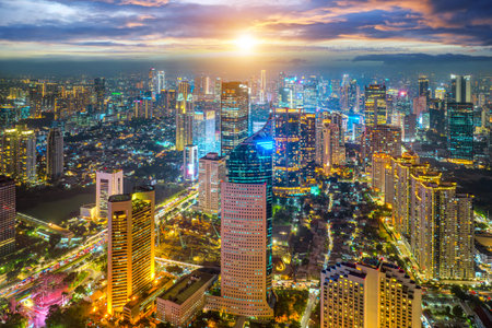 Night aerial view of skyscrapers and multi lane highway in large urban city center Cityscape of high rise buildings in Jakarta, Indonesia at nightの写真素材