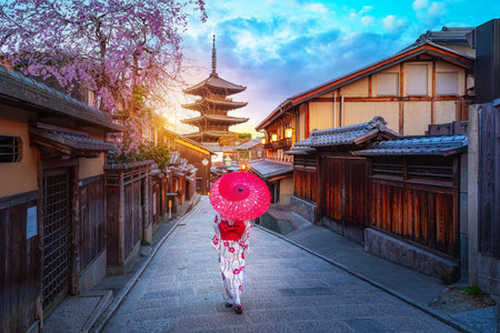 Young Japanese woman in traditional Kimono dress with Yasaka Pagoda at Hokanji temple in Kyoto, Japan during full bloom cherry blossom in springの写真素材
