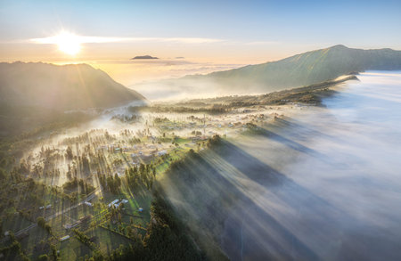 Aerial view of foggy morning in the mountain valley with sunrise. beautiful morning, Mount Bromo....