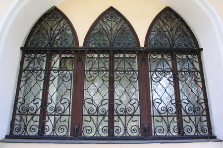 Old arched window with metal grating