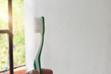Toothbrush holder in hand on the moaning and is on white backgroundの写真素材