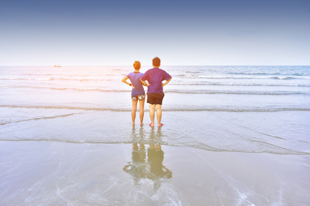 People standing on beach at sea under blue sky,Love on the beachの写真素材