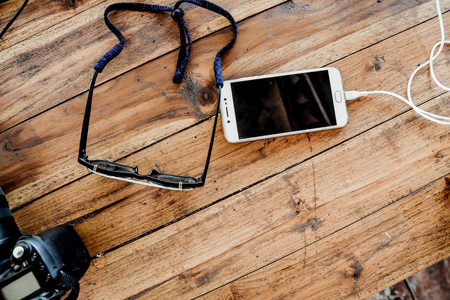 Smart phone on wooden table copy spec for texture concept or design,Vintage style and Summer holiday conceptの写真素材