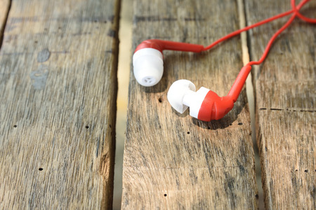 Red earphone on wooden table background for Entertainment music conceptの写真素材