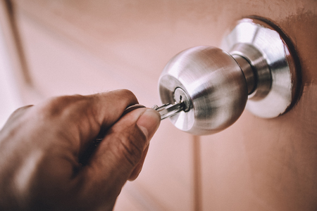 Hand is opening the door knob with the key.の写真素材