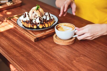 Close up Hand holding coffee cup of  People are in coffee shopの写真素材