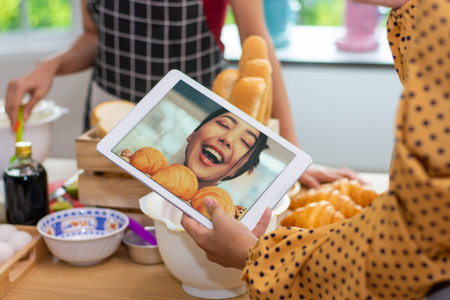 Closeup hand holding tablet small business online happy with Croissant in bakery shop