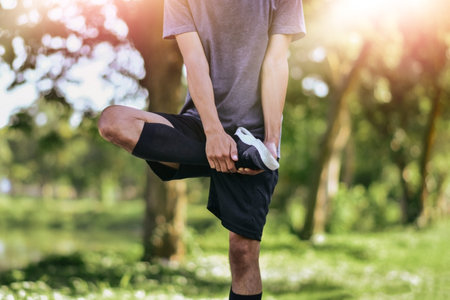 man stretching his leg muscles before exercising, Young male jogger athlete training