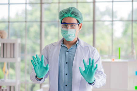 doctor is wearing anti-germ gloves before operating in the lab.の写真素材