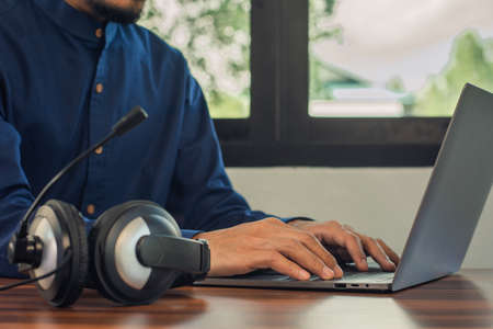 Man are call center headphone online support at home , Men working by computer online technologyの写真素材