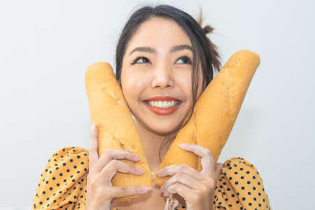 Portrait Woman happy with  bread in bread shop, Women holding bread smile in bakery shopの写真素材