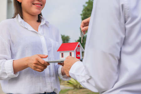 Women happy new home buying real estate , Hand holding home smileの写真素材