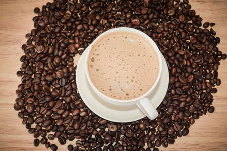 Top view of coffee milk with beans on wooden table for coffee shop concept,Food and drinkの写真素材