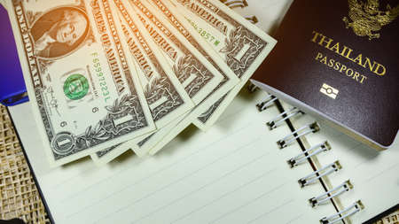 Thailand passport against dollar for every day shopping,One dollar banknote is on wood floor,Money of Americaの写真素材