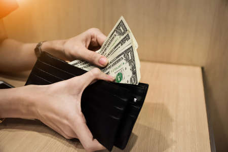 Hand holding dollar for pay or buy product at supermarket,Money for everyday shopping and Investment for saving conceptの写真素材