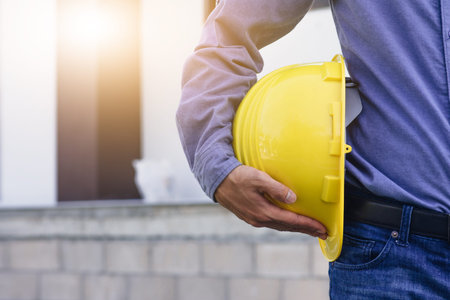Architecture Engineer holding hard hat on site building construction backgroundの写真素材