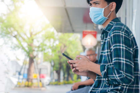 Man wear face mask using mobile smartphoneの写真素材