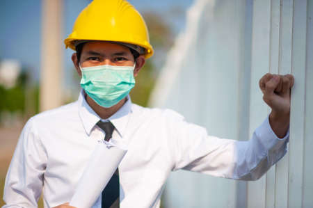 Engineer hold paper work or blueprint and survey on site constructionの写真素材