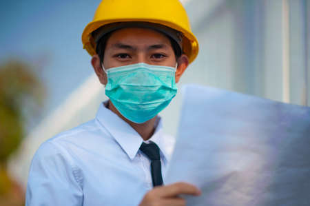 Engineer hold paper work or blueprint and survey on site constructionの写真素材