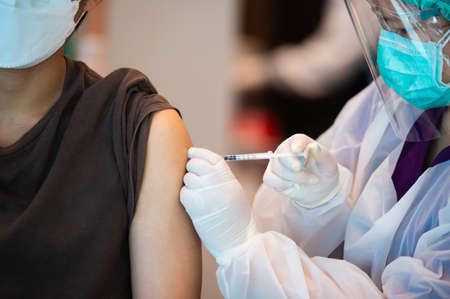 Doctor is vaccinating against COVID-19 to the people to build a group immune systemの写真素材
