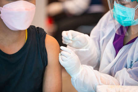 Doctor is vaccinating against COVID-19 to the people to build a group immune systemの写真素材