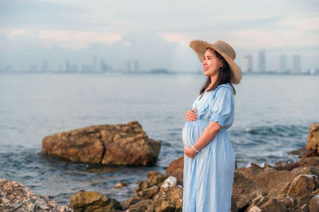 pregnant women travel happy holidays sunset beach backgroundの写真素材