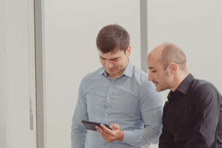 Two businesspeople looking phone trading onlineの写真素材