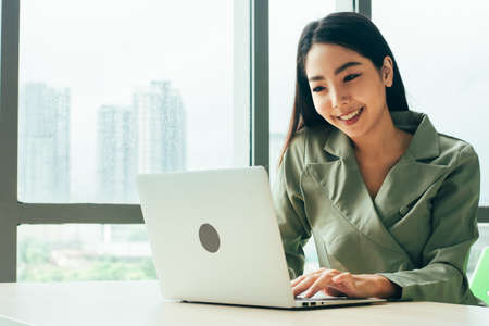 Businesswoman are smile and using computer at window office Trade stock marketの写真素材