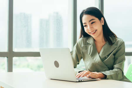 Businesswoman are smile and using computer at window office Trade stock marketの写真素材
