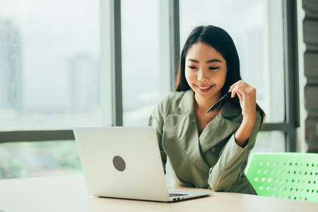 Businesswoman are smile and using computer at window office Trade stock marketの写真素材