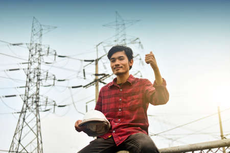 Technician holding white hat safety hard hat sunlight backgroundの写真素材