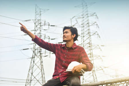 Technician holding white hat safety hard hat sunlight backgroundの写真素材