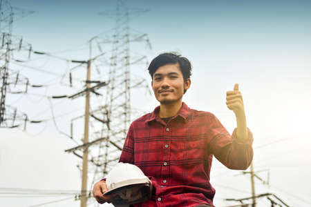 Technician holding white hat safety hard hat sunlight backgroundの写真素材