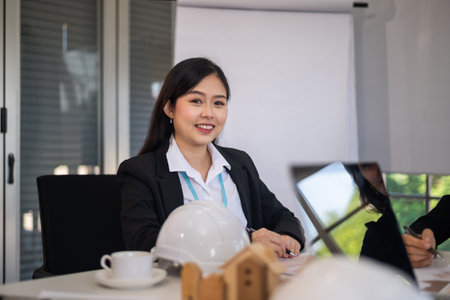 Asian businesswomen sitting in office looking smile at cameraの写真素材
