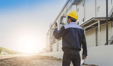 Engineer standing factory plant background , Technician workplace manufacturing maintenance facilityの写真素材
