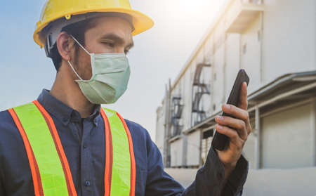Engineer holding smartphone send message internet technology , Engineer construction inspection building projectの写真素材