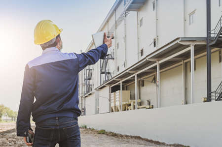 Engineer standing factory plant background , Technician workplace manufacturing maintenance facilityの写真素材