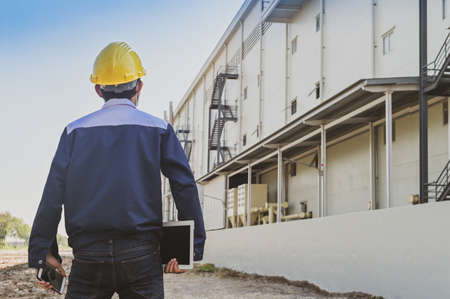 Engineer standing factory plant background , Technician workplace manufacturing maintenance facilityの写真素材