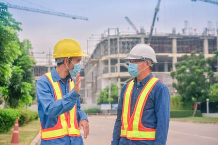 Asian engineer and foreman worker with touch pad discuss, plan working for the outdoors building construction site.の写真素材