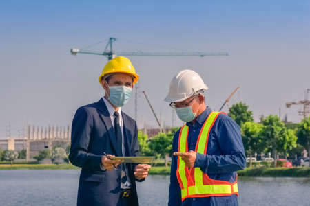 Asian team Construction engineers supervising progress of construction project stand on new factory, Engineering Consulting People on construction site Building inspector.の写真素材
