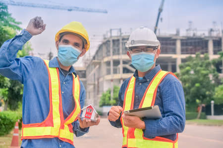 Asian engineer and foreman worker with touch pad discuss, plan working for the outdoors building construction site.の写真素材